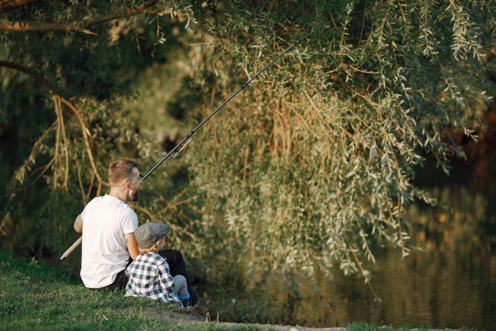 La pêche en Auvergne, une activité incontournable young father fishing together with his little toddler son near t